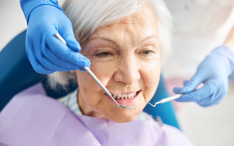 senior female receiving dental treatment from a medic